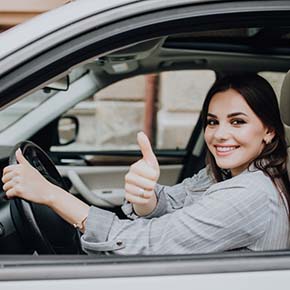 young girl is showing thumbs up at driving test in Irving TX